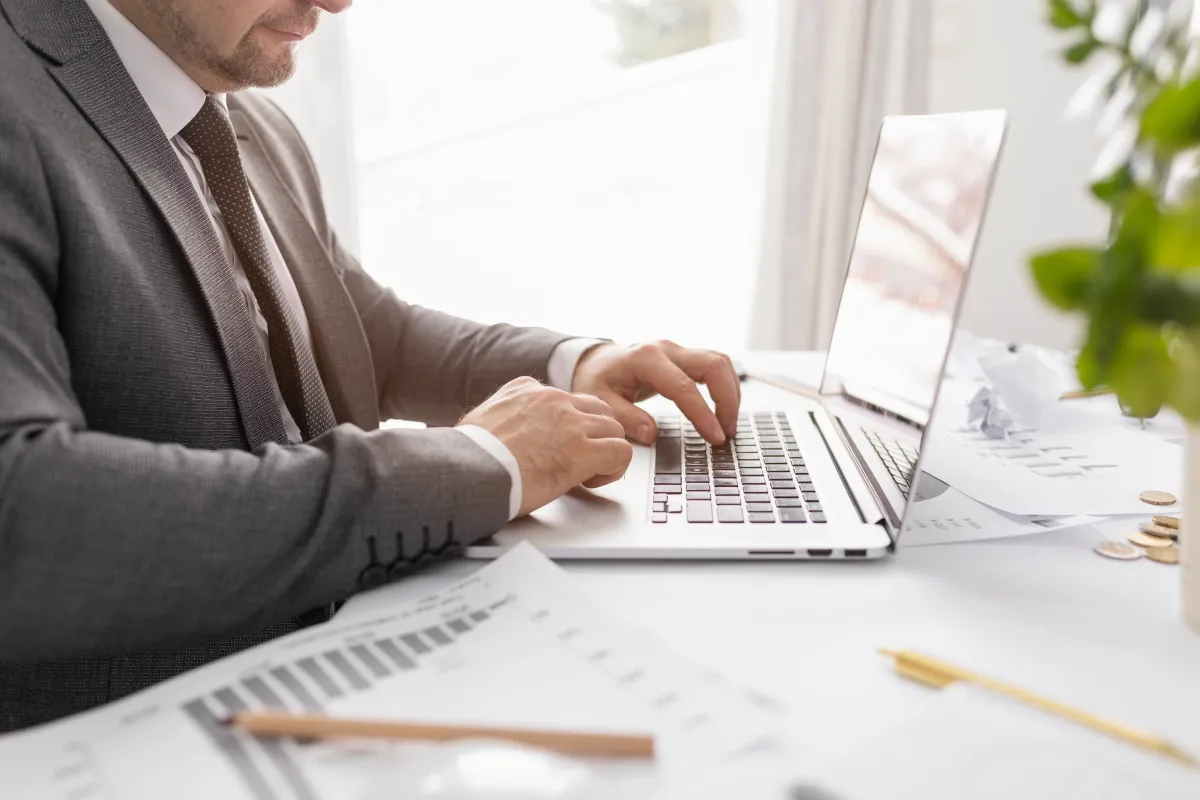 Office worker completing a job application on a laptop with reference documents